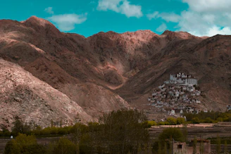 brown mountains near houses and lake