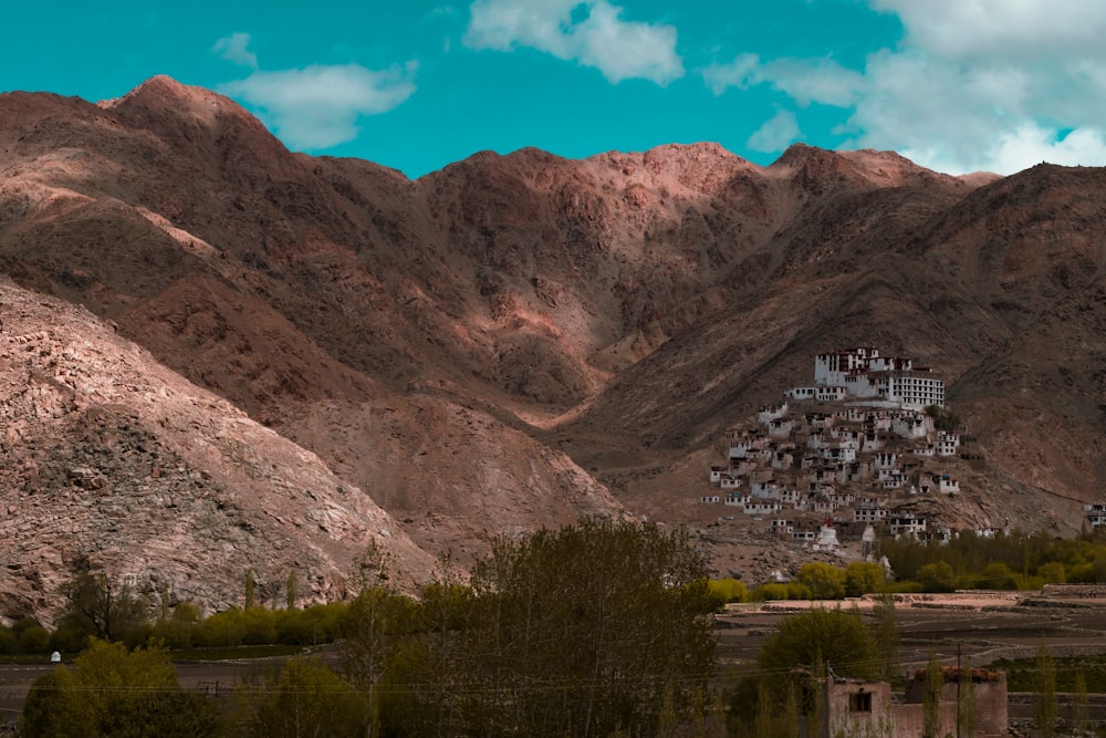 brown mountains near houses and lake