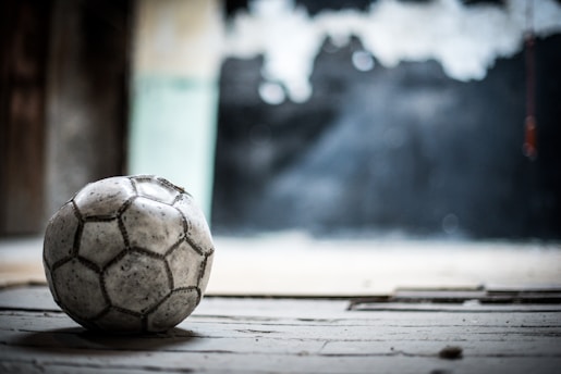 A film reel and a soccer ball placed on a wooden table.