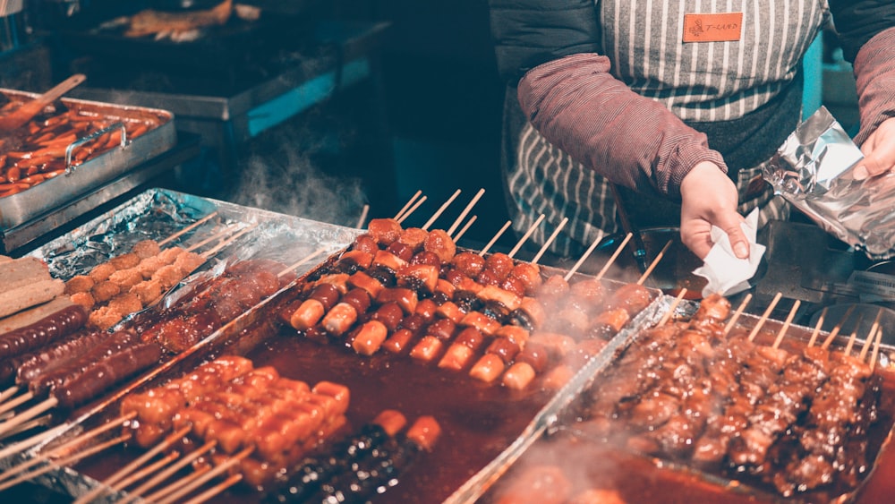 串刺し料理のそばに立つ人々