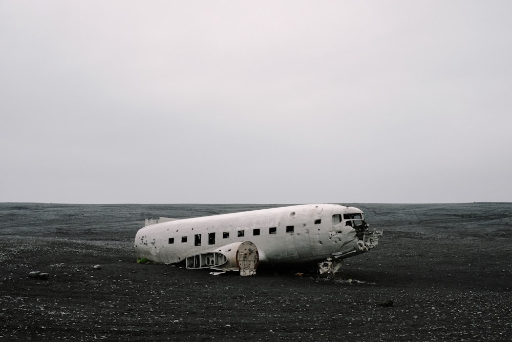 Avión destrozado sobre arena gris