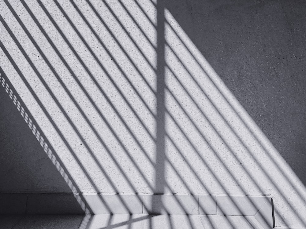 a black and white photo of the shadow of a wall