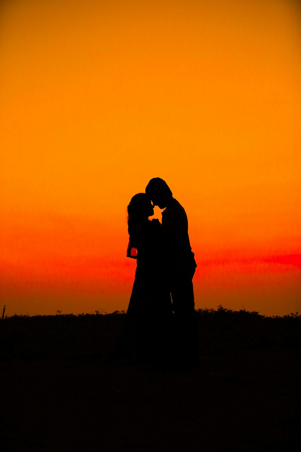 silhueta do homem e da mulher durante o pôr do sol