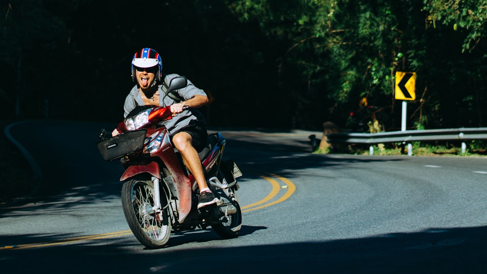 man riding motorcycle on curved road