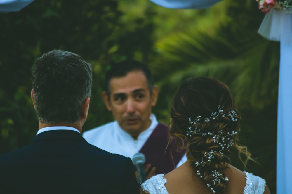 man in woman in front of man holding microphone