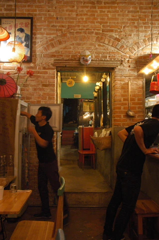 A warm, cozy Scandinavian-style restaurant scene with a team member capturing behind-the-scenes content on a camera.