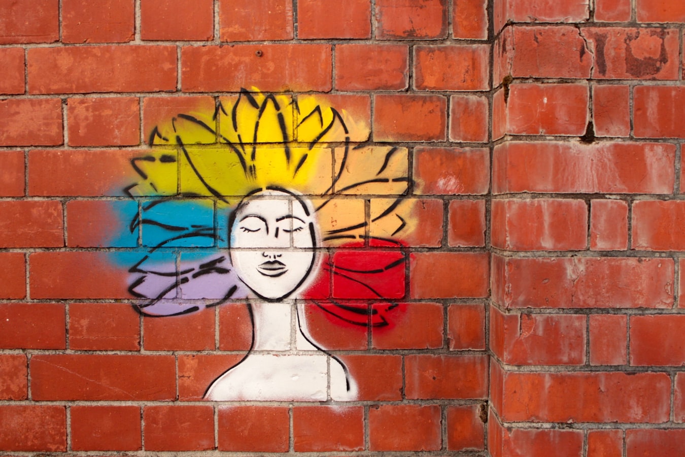 paint spray art of woman on brown brick wall