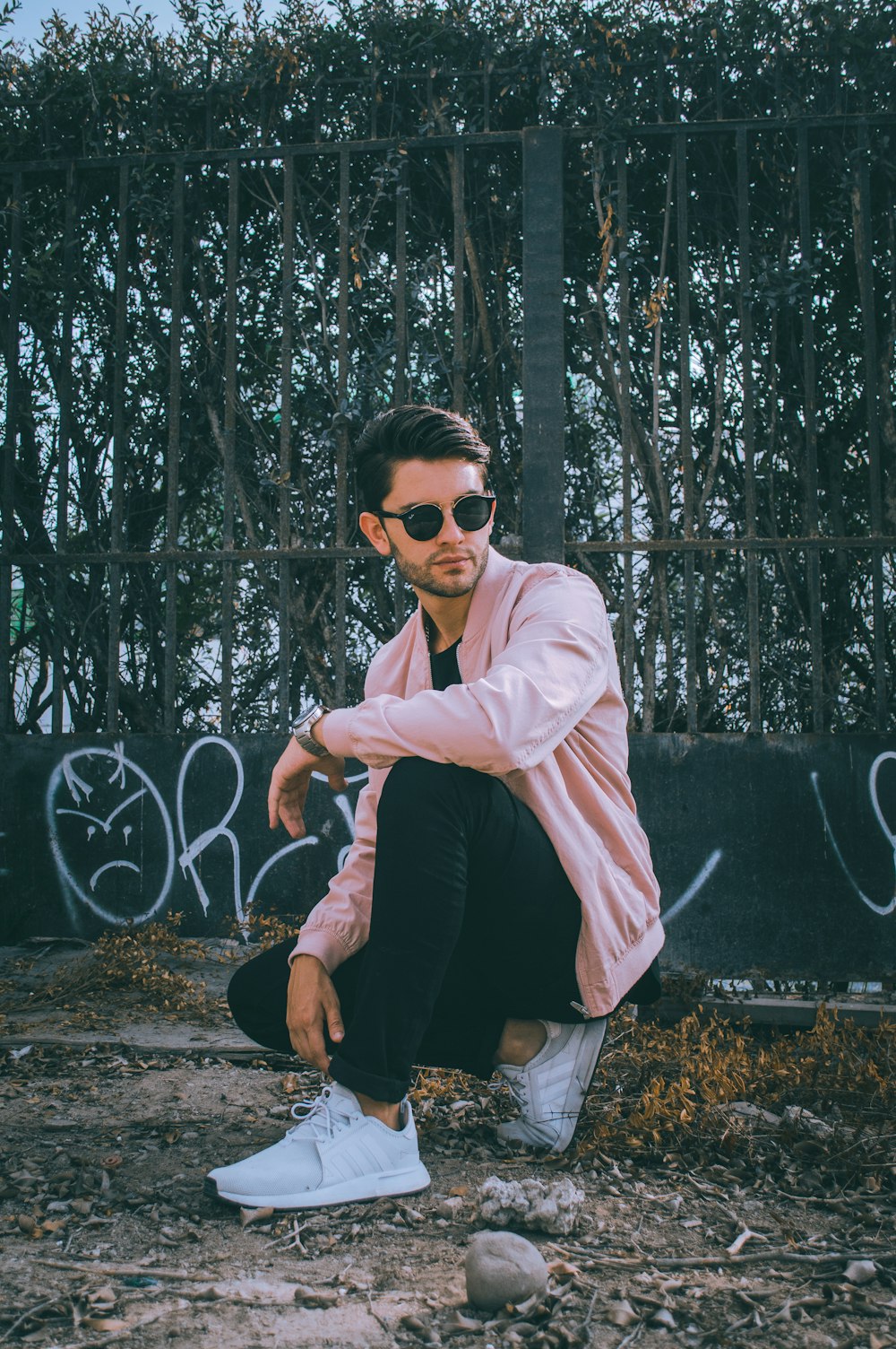 man in pink dress shirt and black pants look to the left