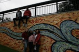 A group of teens painting a mural in a neighborhood.