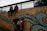 A group of young street artists collaborating on a vibrant mural at dusk.