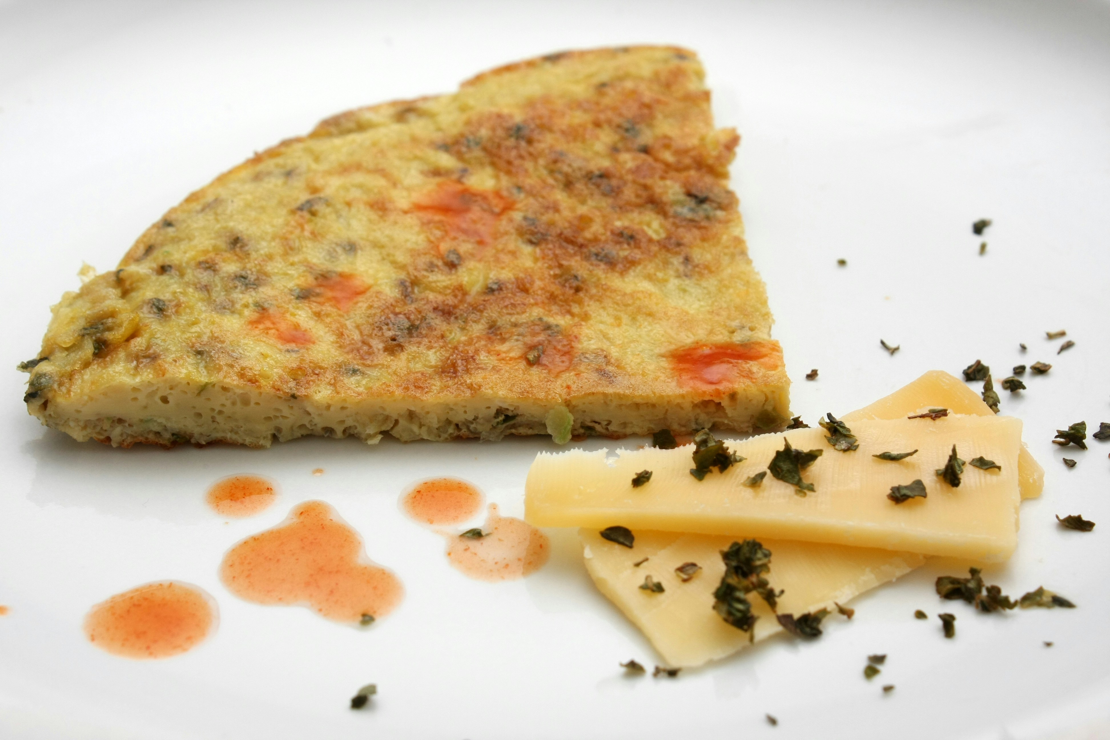 Warm golden omelette with melted cheese and crispy bacon on white plate, soft morning kitchen light