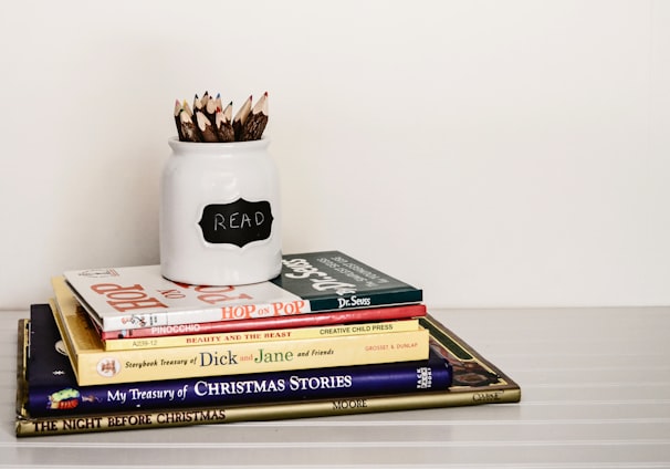 white ceramic pencil organizer on top of stack of books