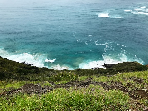 A scenic cliffside view overlooking turquoise ocean waters and rocky formations.