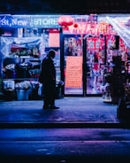 Wide shot of a storefront with a glowing custom lighted sign at night.