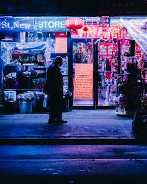 Wide shot of a storefront with a glowing custom lighted sign at night.