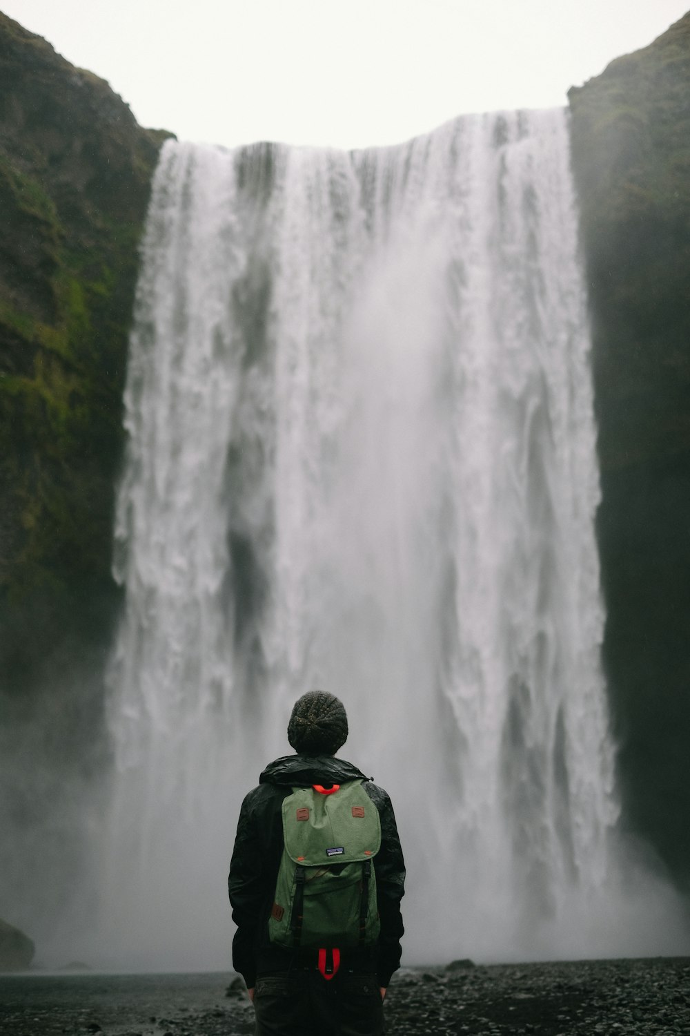 person standing in-front of waterfalls