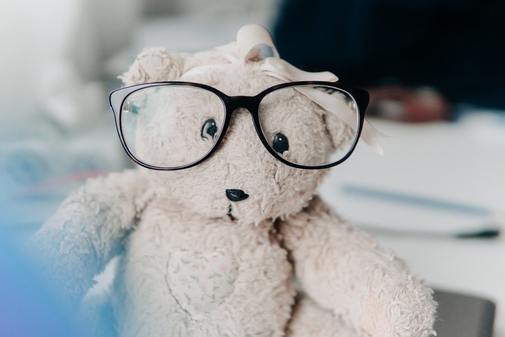 Brinquedo de pelúcia de urso branco usando óculos