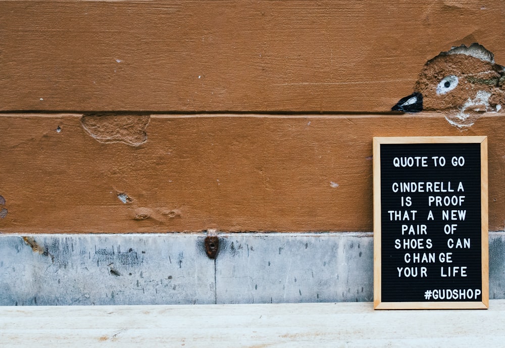 chalkboard leaning on brown concrete wall