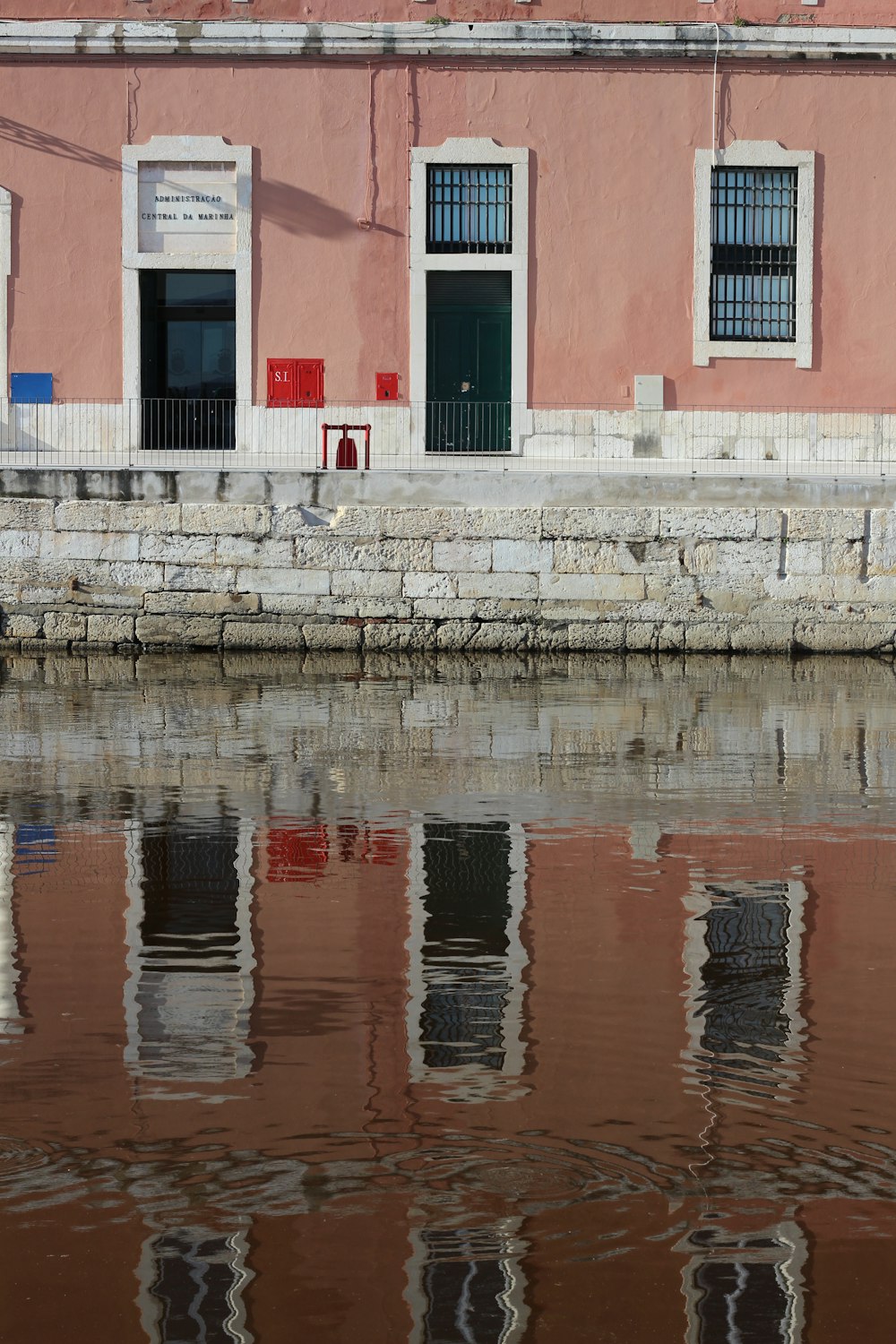 edificio in cemento marrone e bianco vicino allo specchio d'acqua durante il giorno