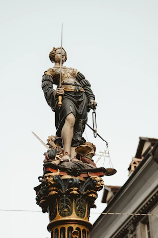 Statue of the blindfolded Roman goddess of justice holding scales, symbolizing fairness.