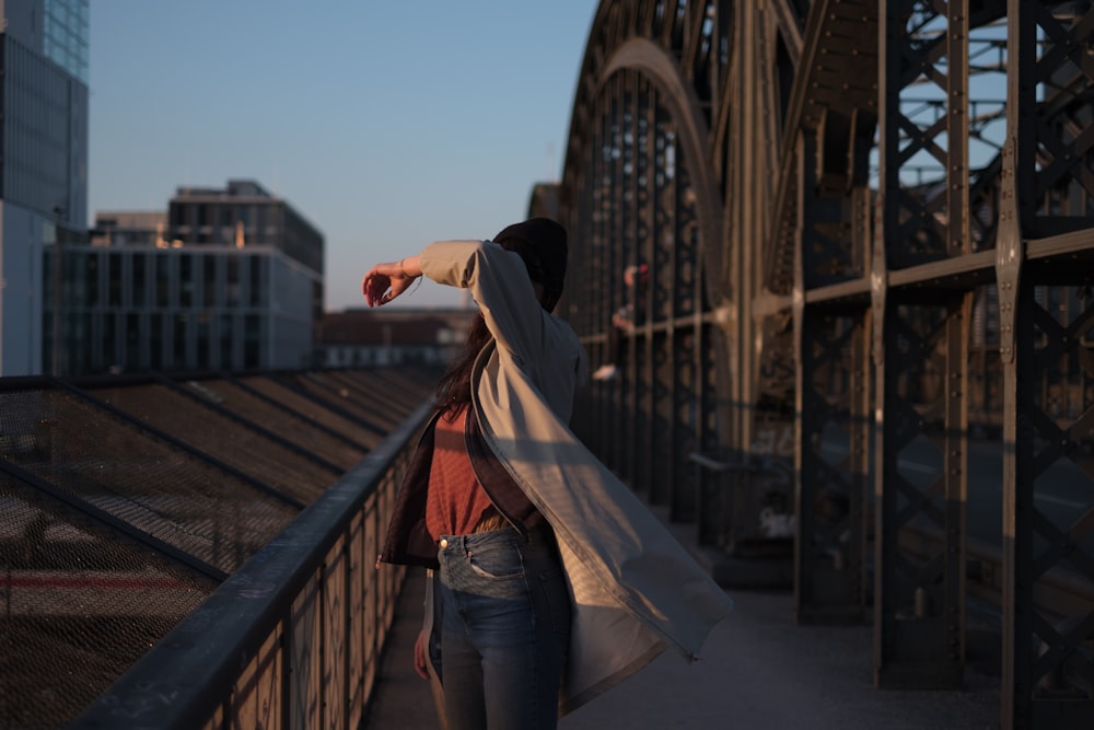 woman standing beside brown steel handrail