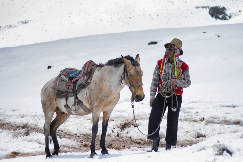 person holding horse tie on snow filled area