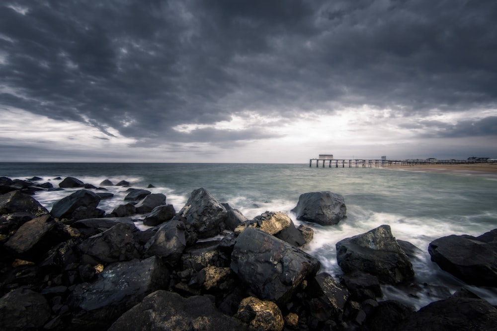 black rocks beside a body of water