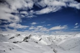 A panoramic view of snow-capped mountains under a clear blue sky.