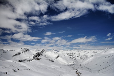A panoramic view of snow-capped mountains under a clear blue sky.