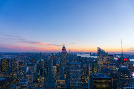 A panoramic global city skyline at dusk with financial district lights.