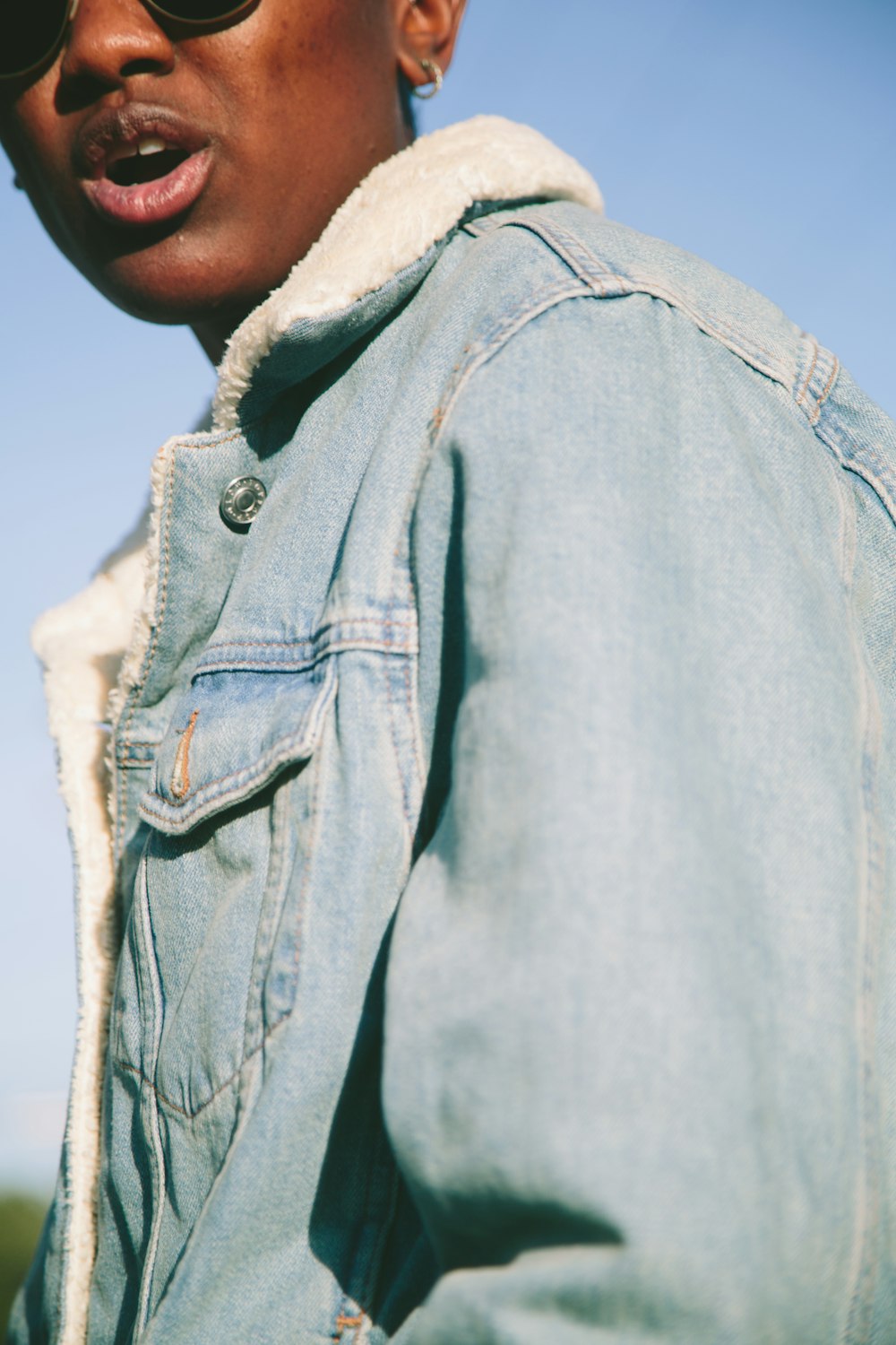 person wearing blue denim sheepskin jacket