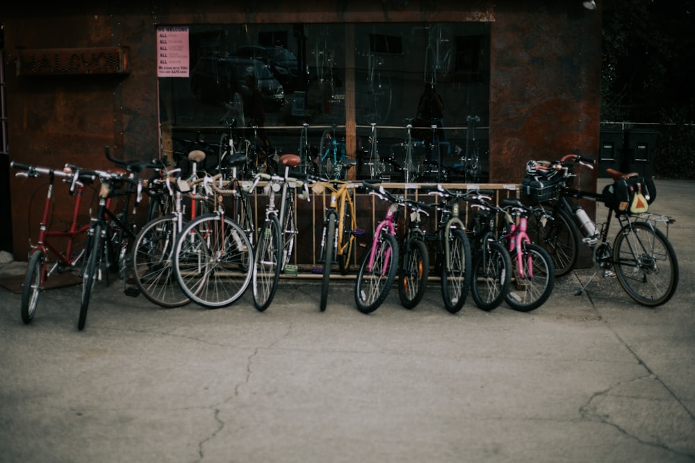 Pila de bicicletas de colores variados sobre pavimento de hormigón