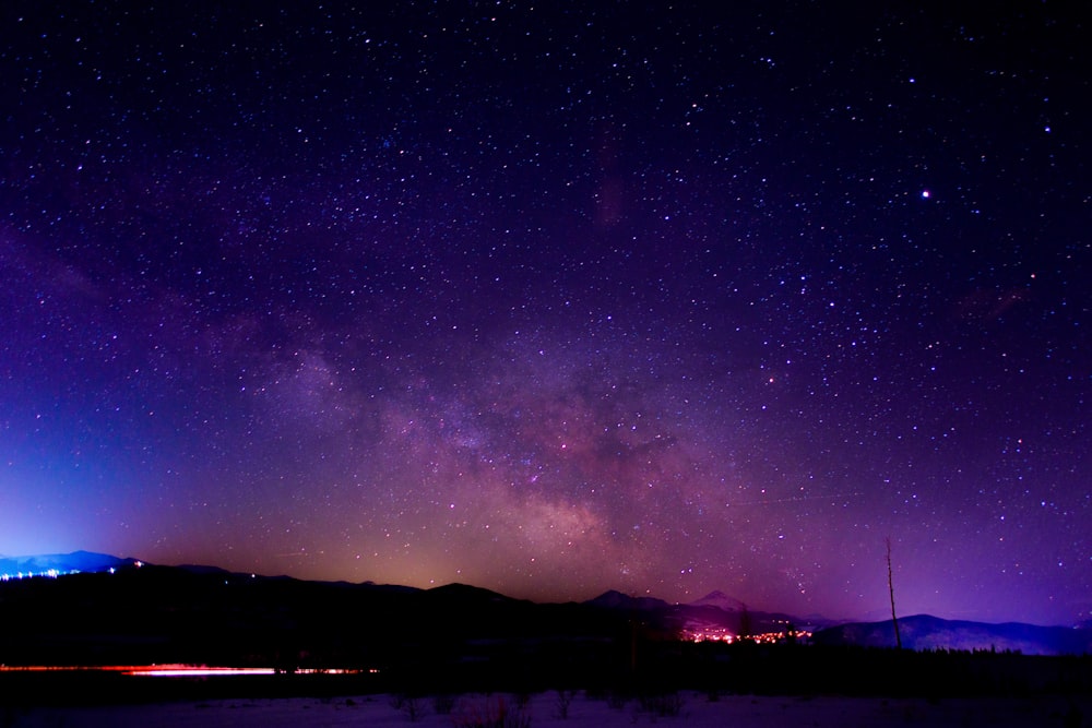 silhouette of mountain under purple nebula