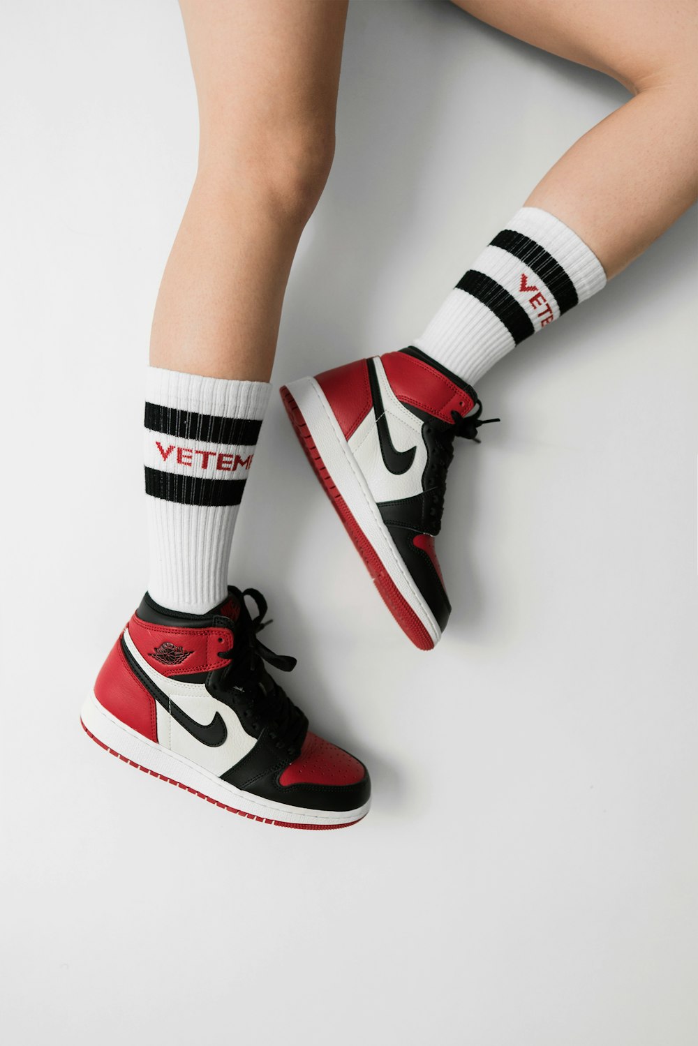 person wearing pair of black toe Air Jordan 1's