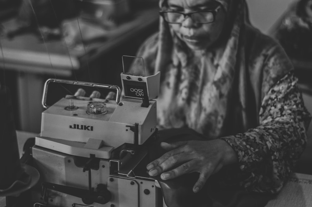 grayscale photography of woman tailoring