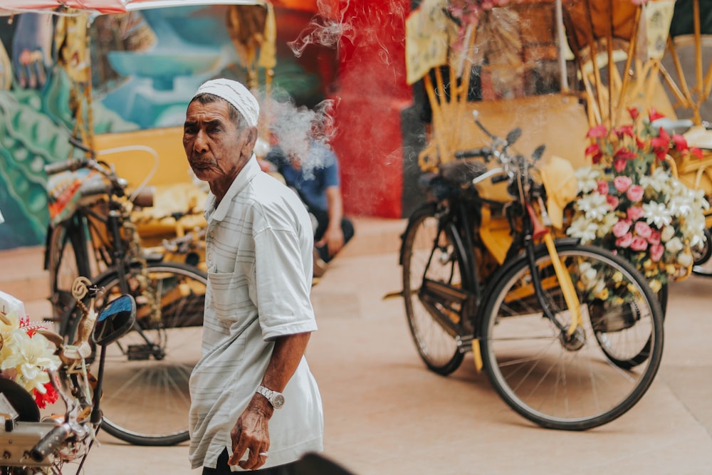 man standing near black bicycle