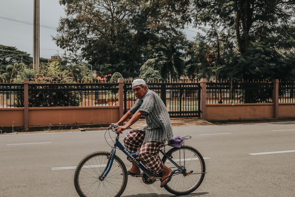 man riding bike near beige wall during daytime