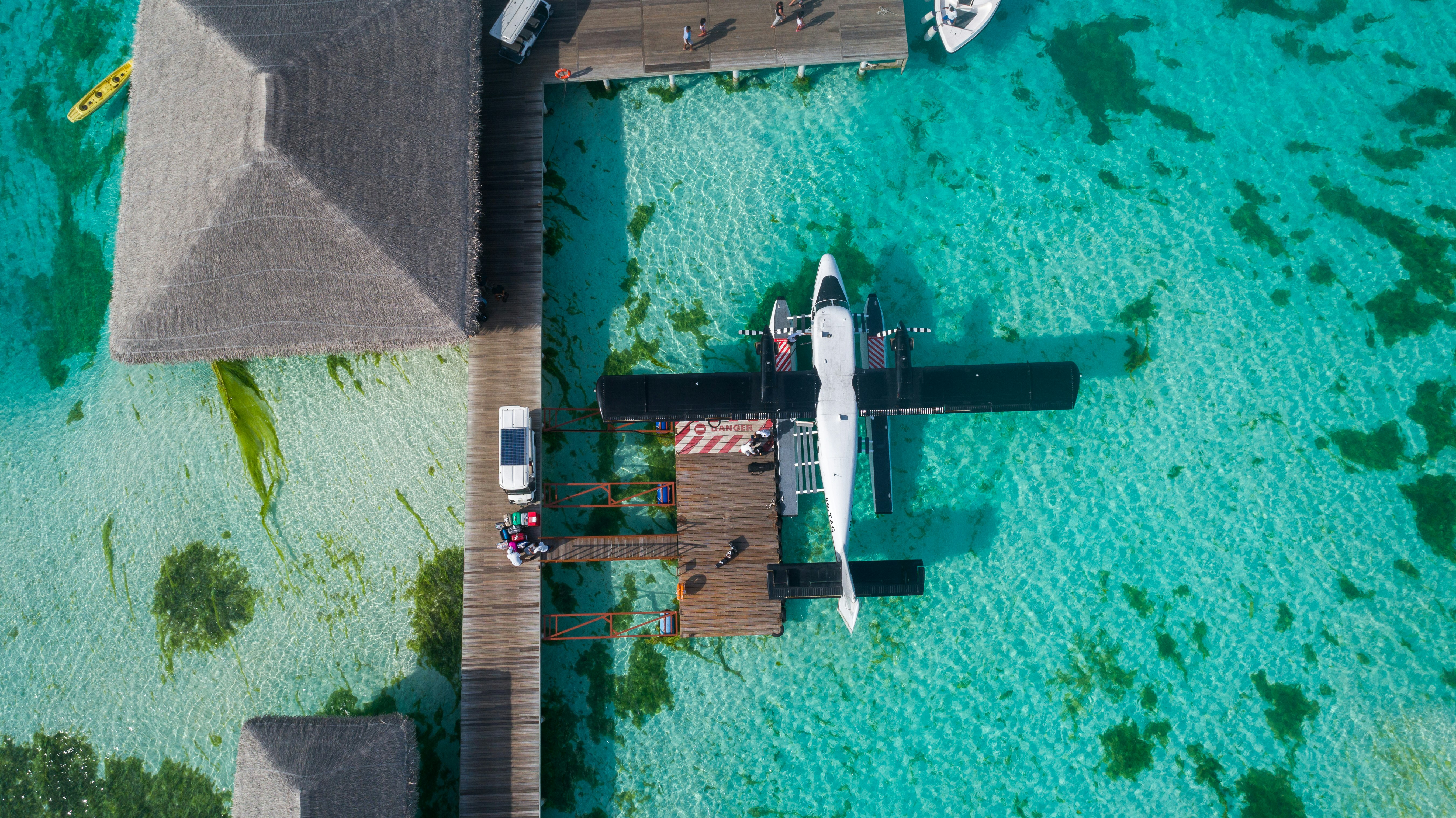 white and black airplane parked on dock top-view photography