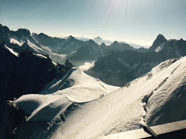 Majestic Himalayan mountains with travelers trekking on a clear day.