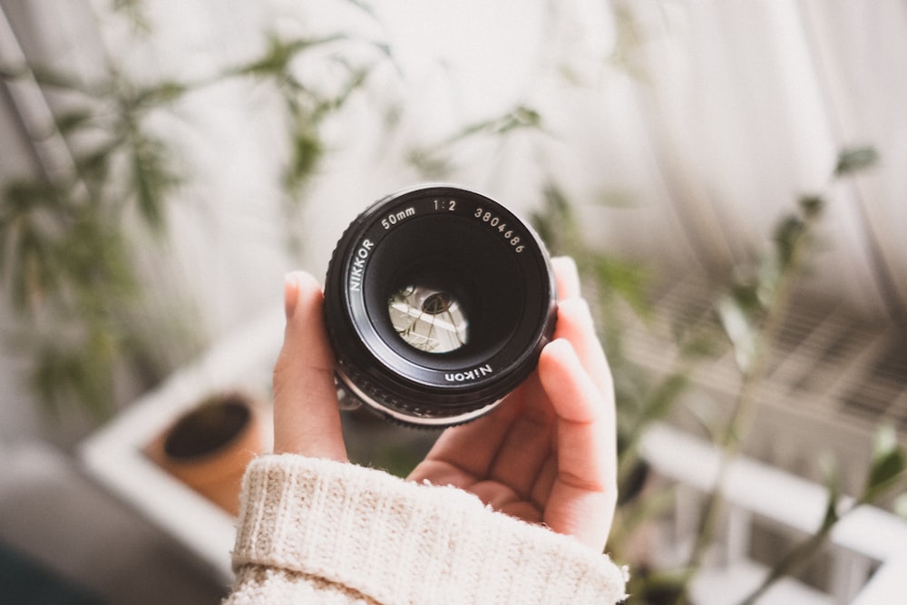 person holding black camera zoom lens