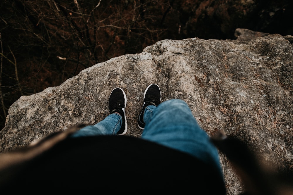 person standing on gray rock