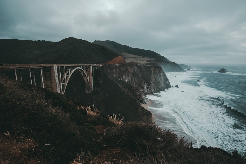 gray bridge between two mountains during daytime