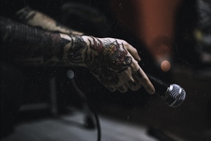 tattooed person holding microphone