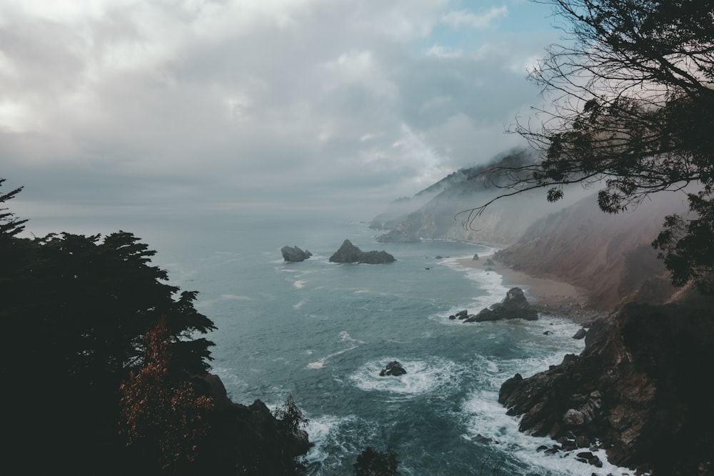 aerial photography of ocean beside mountain