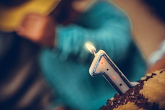 Close-up of a camera lens focusing on a smiling birthday celebration.