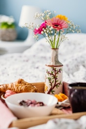 Elegant breakfast basket with flowers, fruits, and a coffee cup on a cozy morning setting