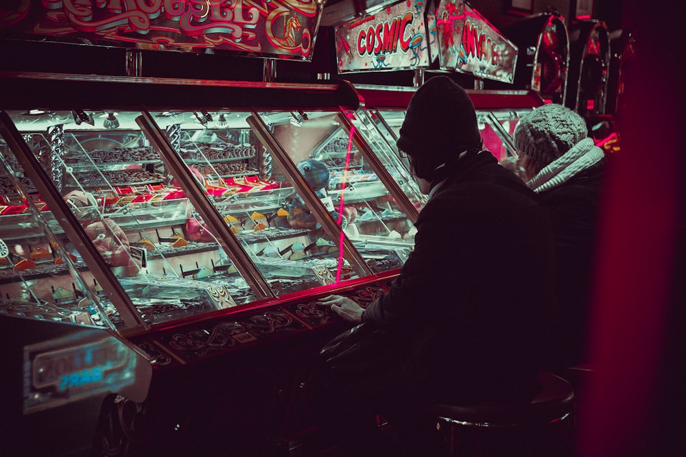 pessoa jogando na máquina arcade