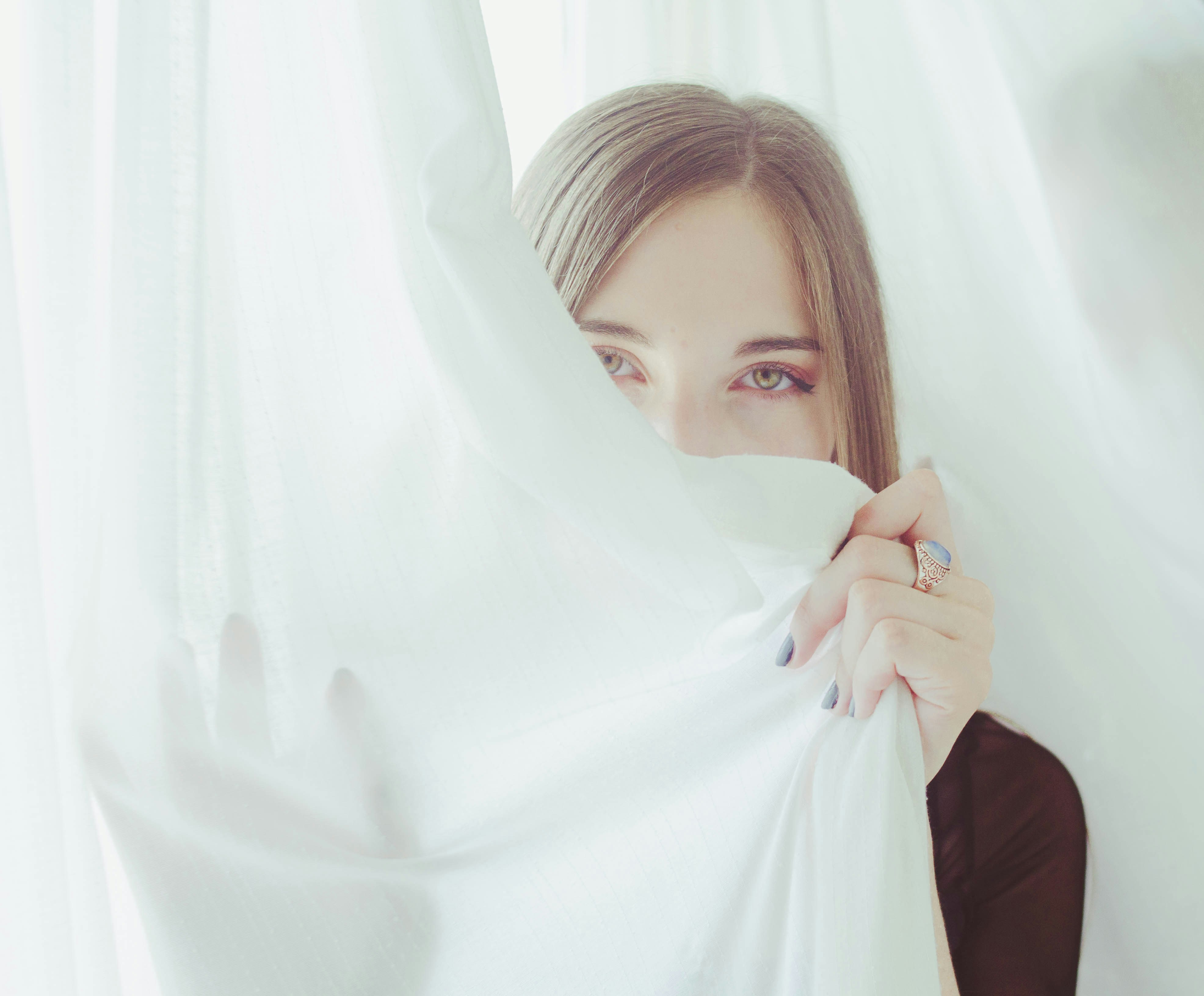woman hiding on cloth sheet teams background