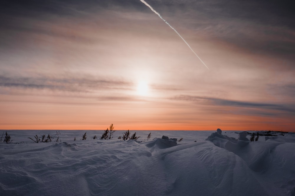 sunlight through clouds over snow field