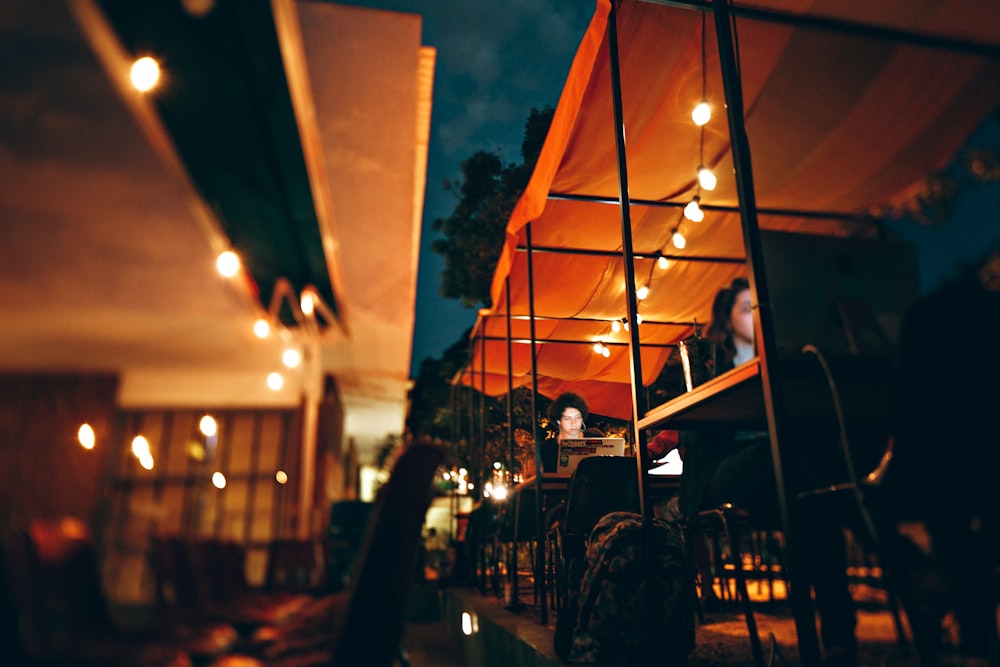 people sitting on chair outside the restaurant during nighttime